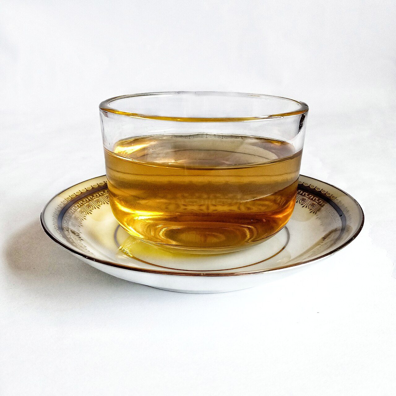 Stress et anxiété : comment l’alimentation peut aider à mieux les traverser ? Infusion dorée dans une tasse en verre posée sur une soucoupe
